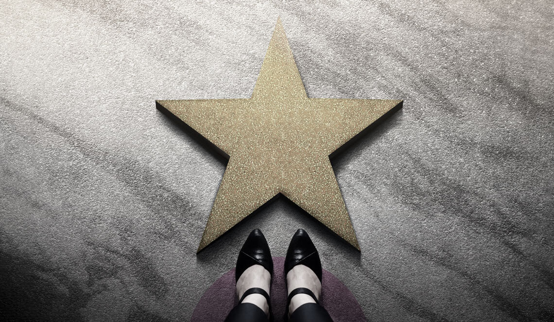 stockphoto feet standing before gold star on floor