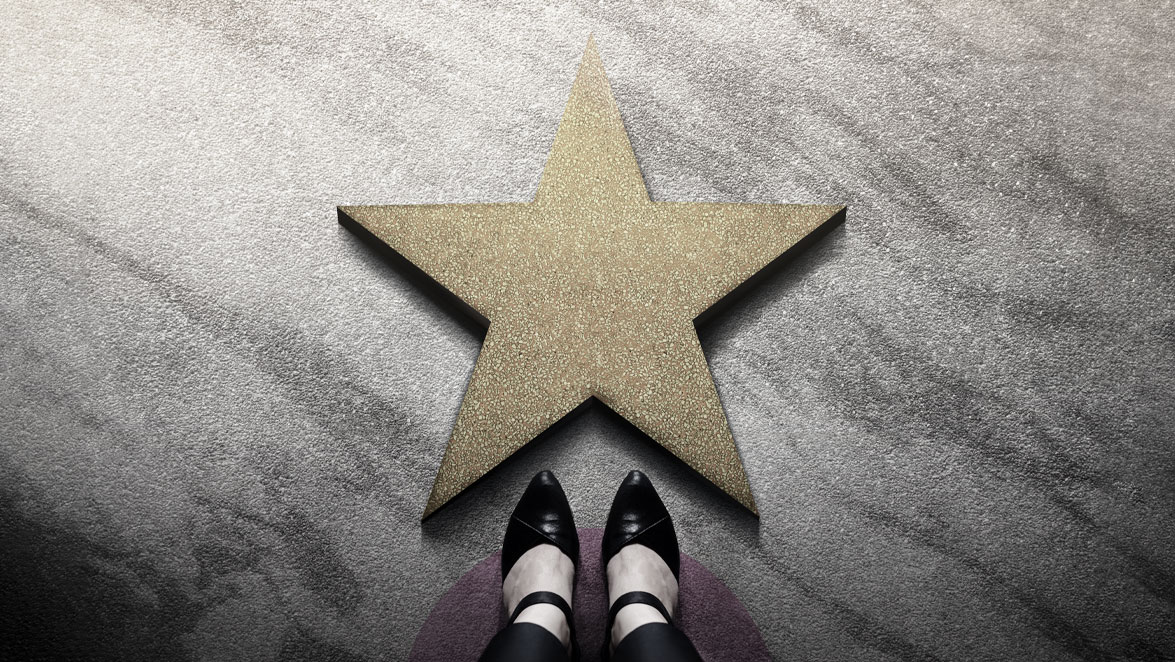 stockphoto feet standing before gold star on floor