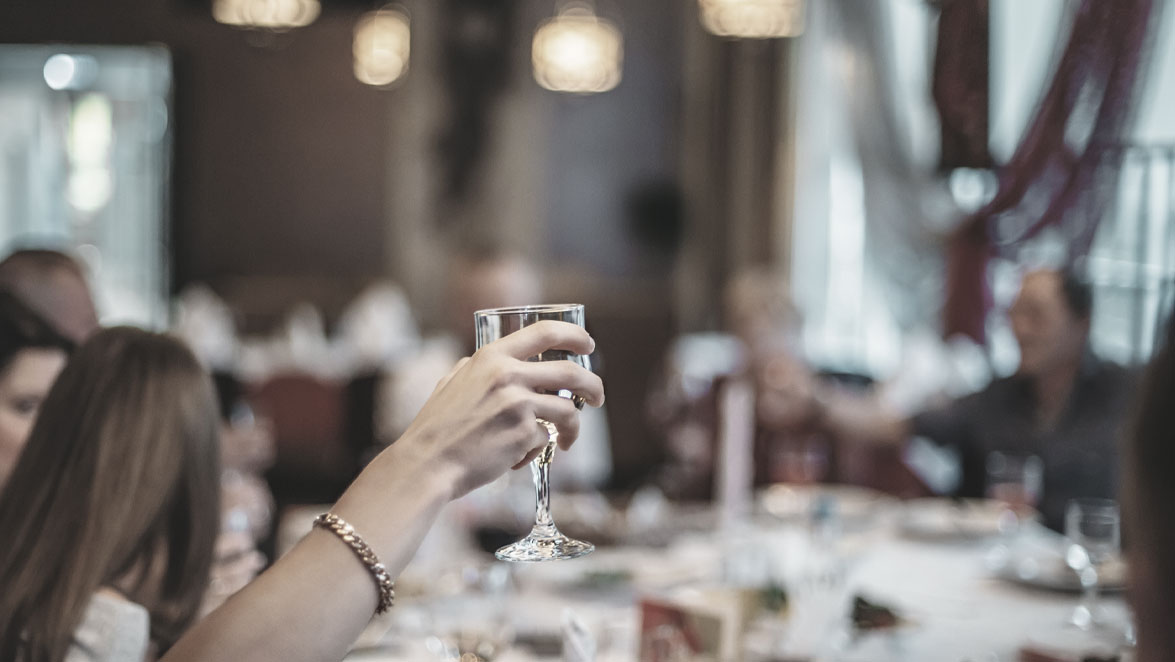 stockphoto hand holding glass elevated at banquet table