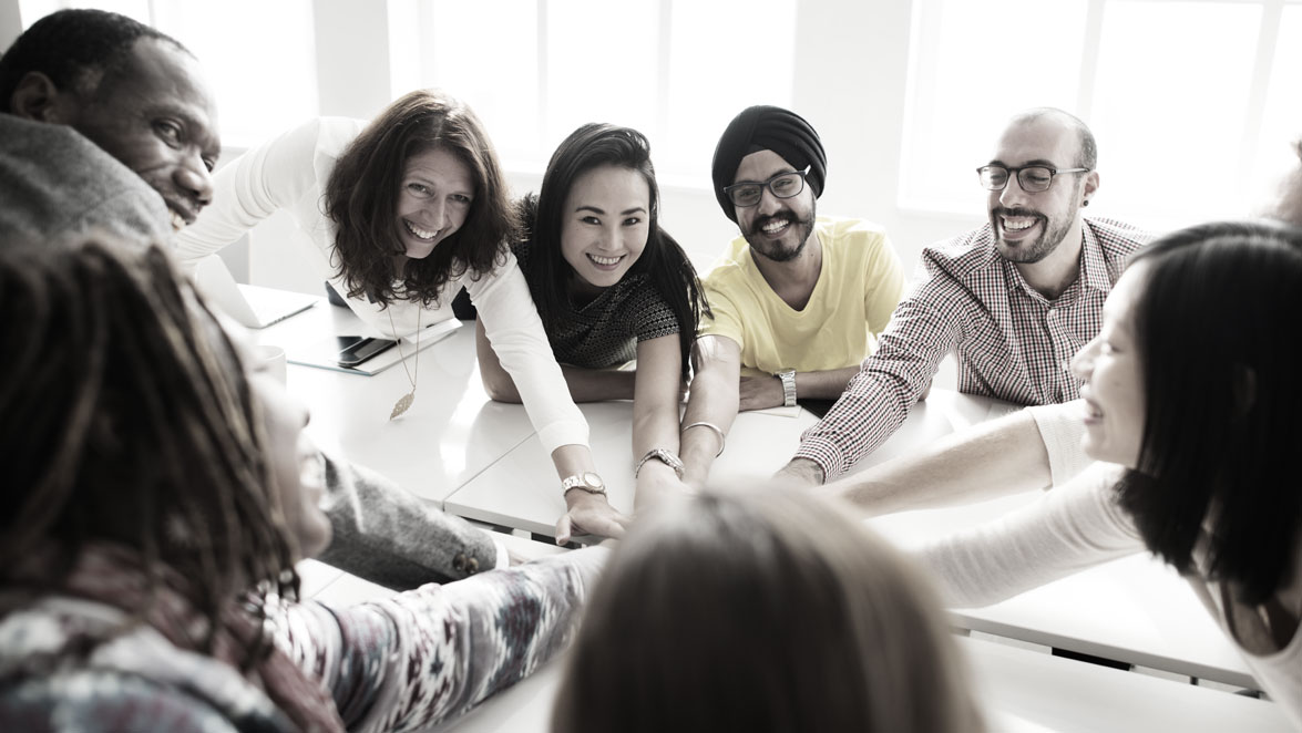 stock photo group of people reaching hands in together over table